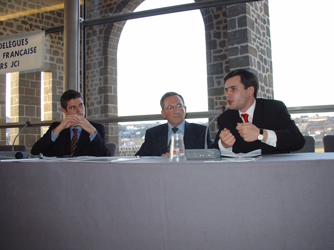 Vendredi 6 février 2004 - Le Puy-en-Velay - Stéphane Jacquemet intervenant à la tribune, aux côtés de Laurent Wauquiez (à gauche), futur Ministre de l'Enseignement Supérieur et de la Recherche, et de Louis Teyssier (au centre), Président du Comité d'Expansion Economique de la Haute-Loire, sur le sujet des Fonds d'Investissement de Proximité (FIP), à l'occasion de l'Assemblée générale annuelle et nationale de la Jeune Chambre Economique Française (JCEF) – © Collection privée - DR.